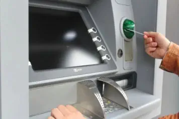 jemand holt Geld vom Bankautomat ab