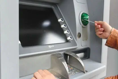 jemand holt Geld vom Bankautomat ab