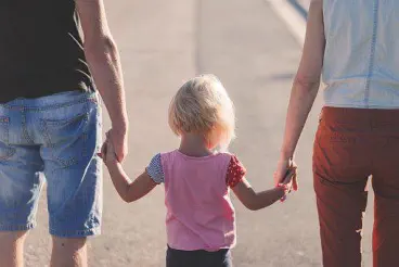 Foto, Eltern gehen mit Kind spazieren